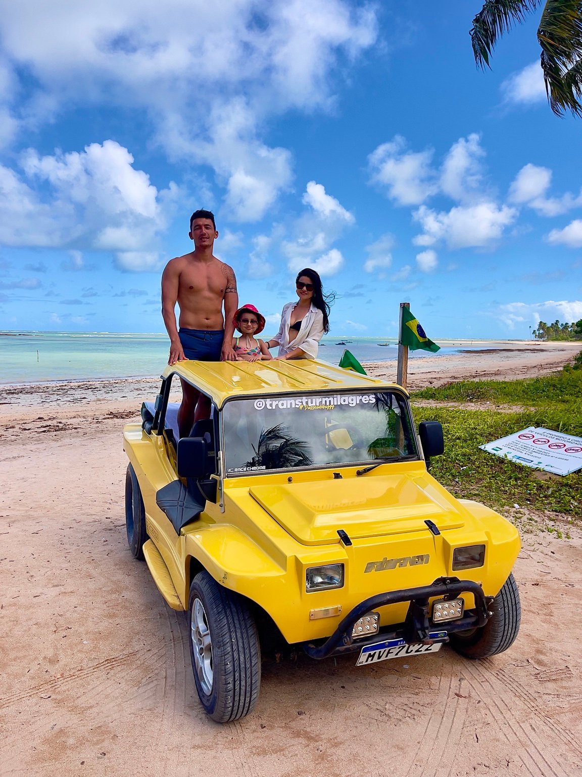 Família em buggy amarelo na praia