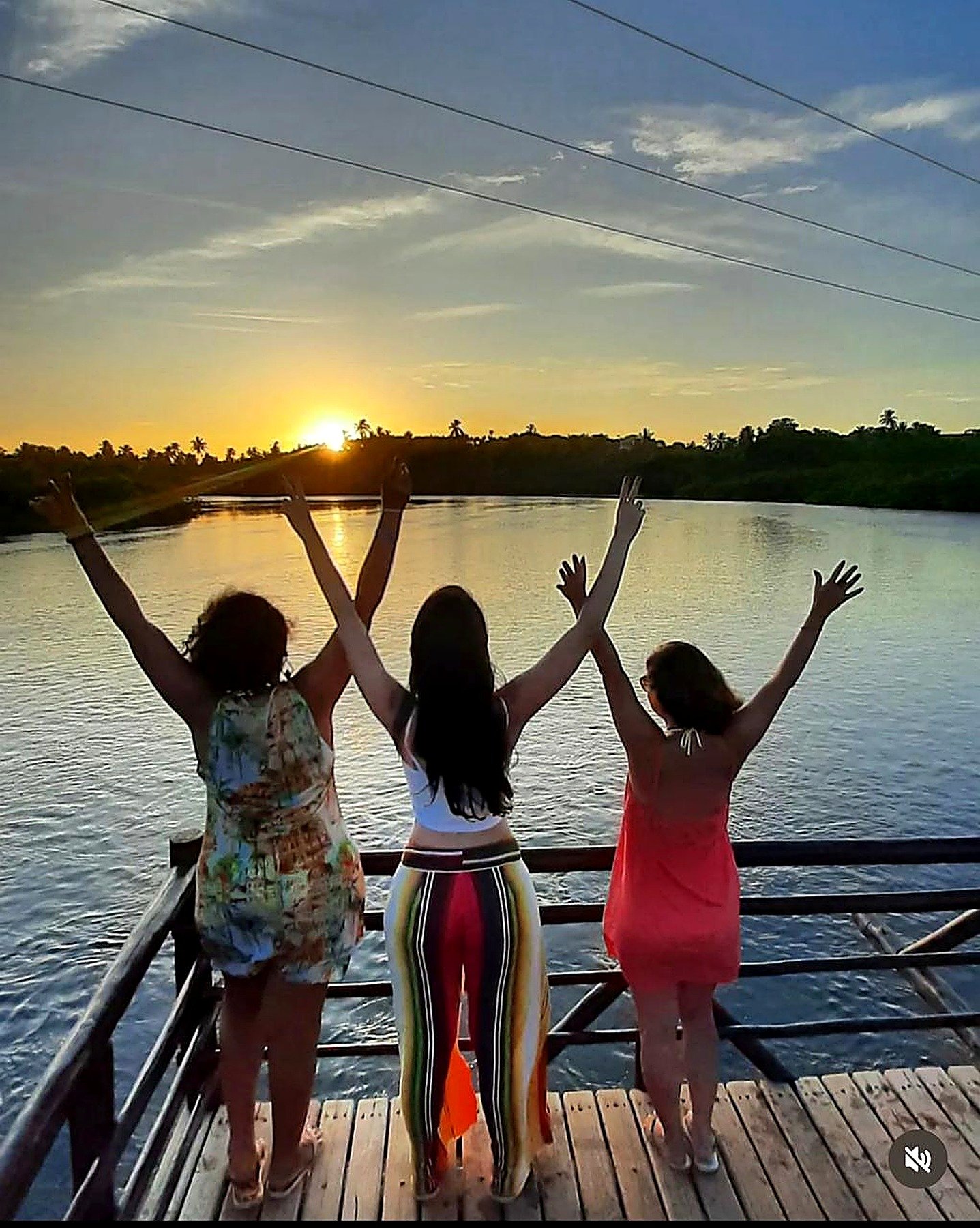 Grupo contemplando o pôr do sol na ponte